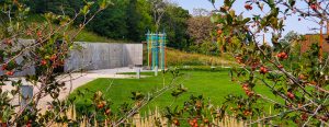 RCTC's colorful Memorial Plaza art sculpture is in the background, with small tree branches that have red berries growing on them in the foreground.